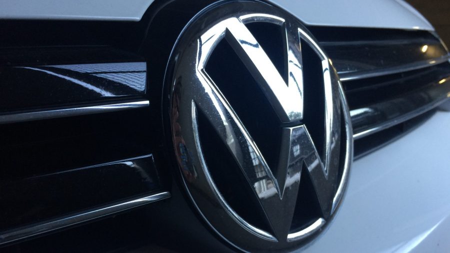 Photo of a Volkswagen emblem on the front grille of the car.