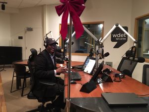 Stephen Henderson smiles with WDET's Festivus Pole in the studio