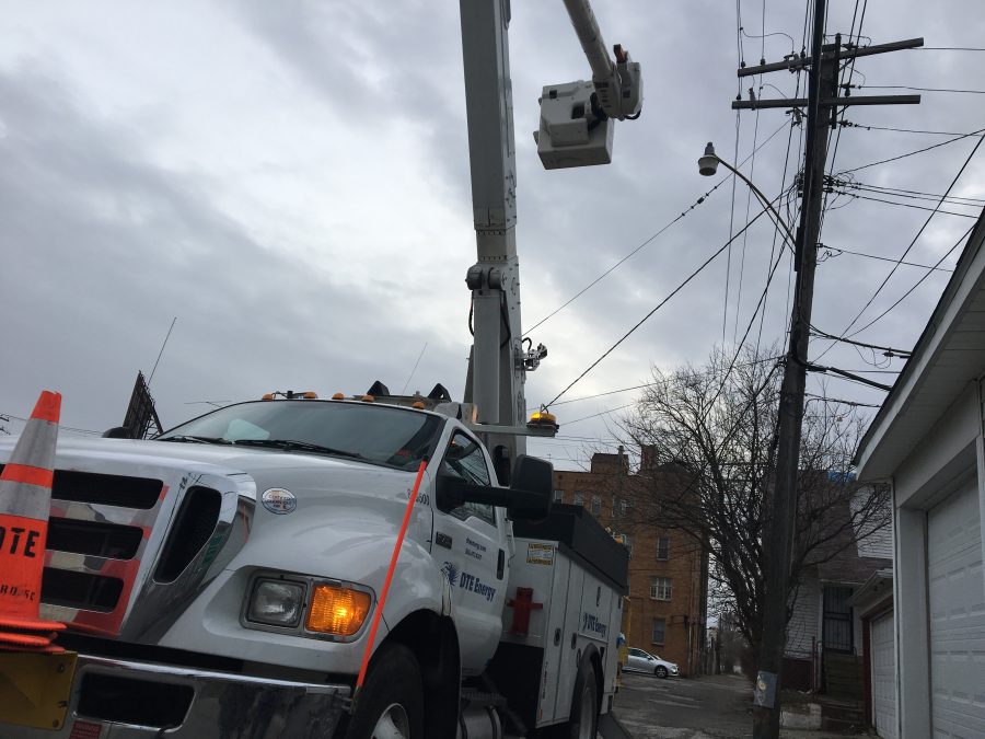 A DTE Energy truck holds up a repair crewman to restore power.