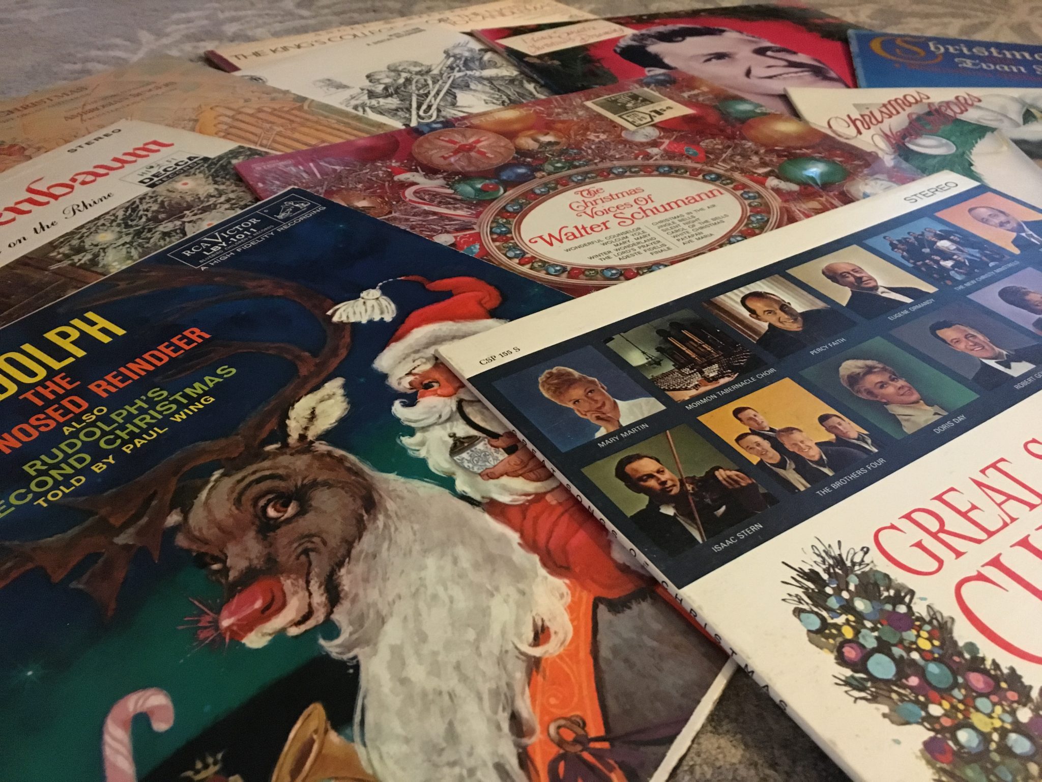 an assortment of Christmas albums are sprawled out on a table
