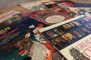 an assortment of Christmas albums are sprawled out on a table