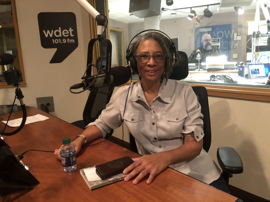 desiree cooper smiles in front of a microphone