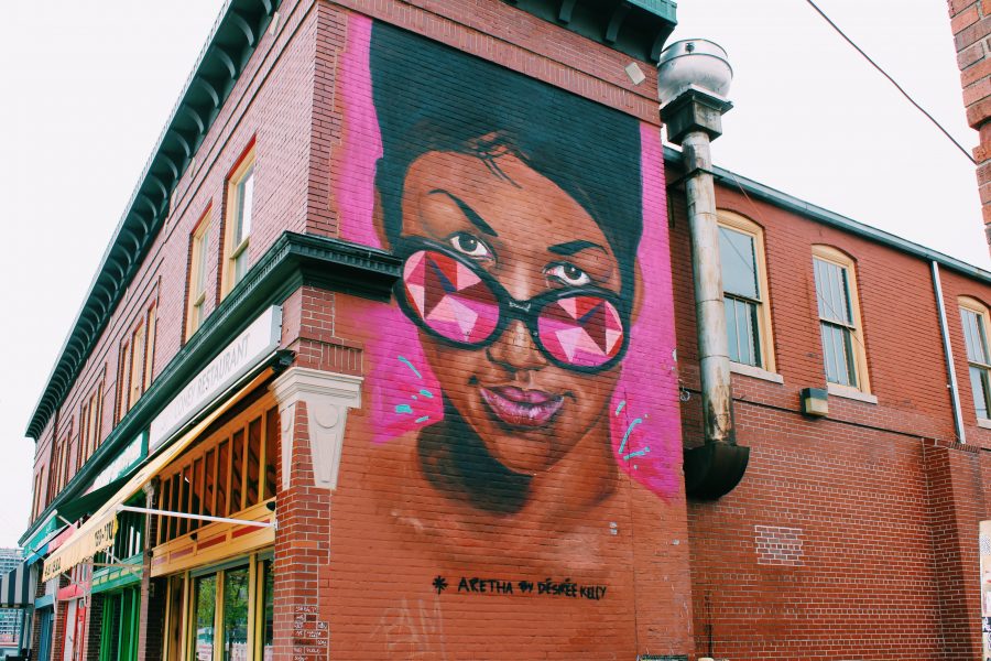 A pink painting of Aretha Franklin on the side of a building