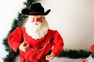 a small Santa figurine wearing a cowboy hat