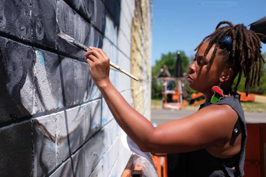 Sydney G James painting a mural