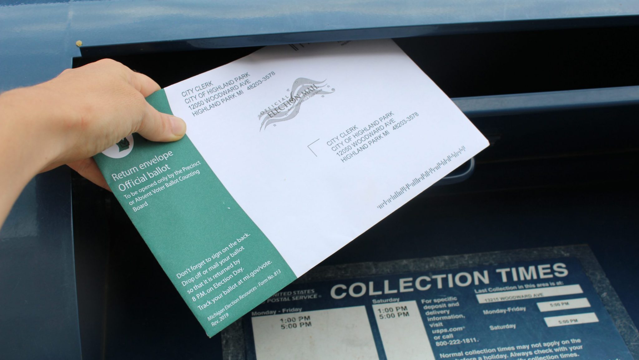 A voter drops an absentee ballot in a mailbox in Highland Park, Michigan.