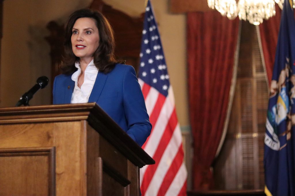 Gov. Gretchen Whitmer speaks at a podium in front of a U.S. flag.