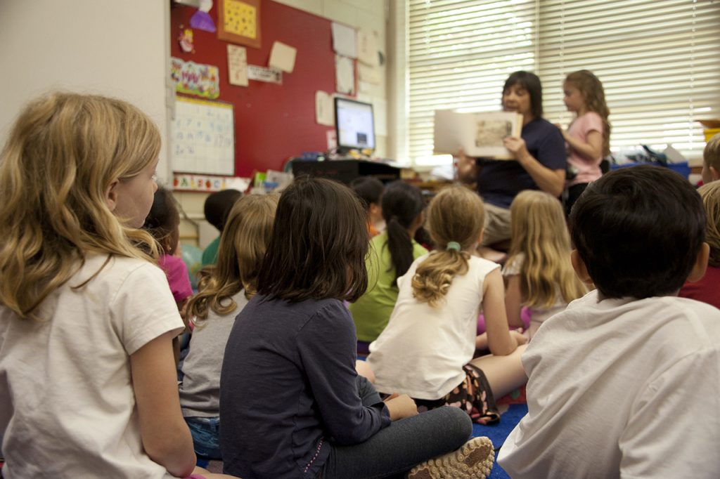 Kids and teacher in classroom stock image