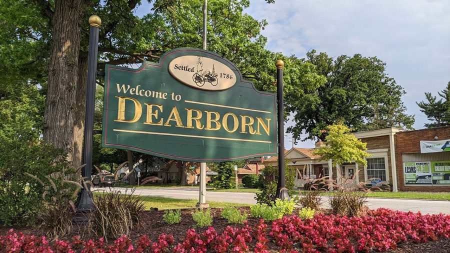 green sign with gold lettering that reads, "Welcome to Dearborn"