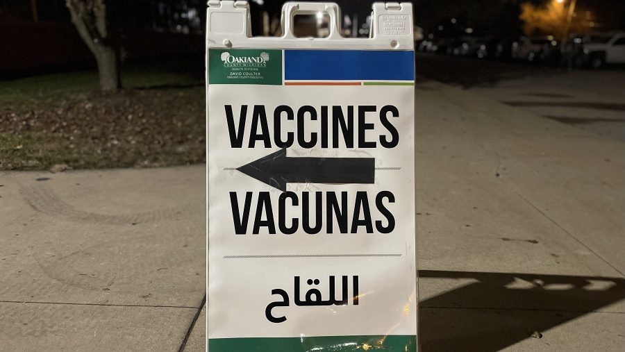 A sign in multiple languages directing to a vaccine clinic.