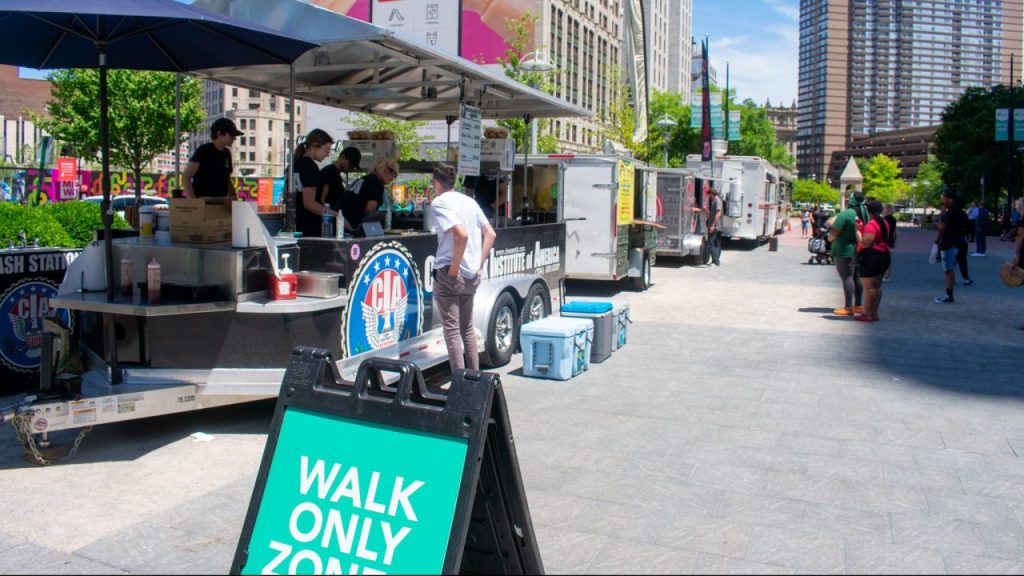 people ordering at food trucks on a sunny day