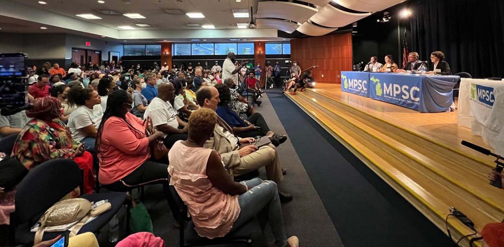 FILE — Dozens gathered in an auditorium for a Michigan Public Service Commission hearing on DTE's proposed rate increase, August 2022.