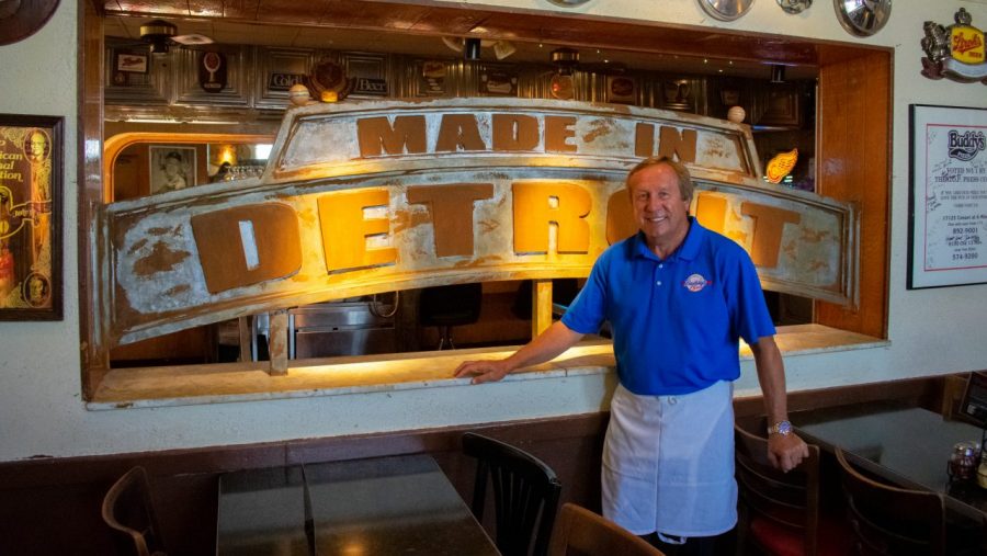 Buddy's chief brand officer Wesley Pikula poses by a sign in the restaurant that reads "Made in Detroit" on Thursday, Aug. 11, at Buddy's Pizza. 
