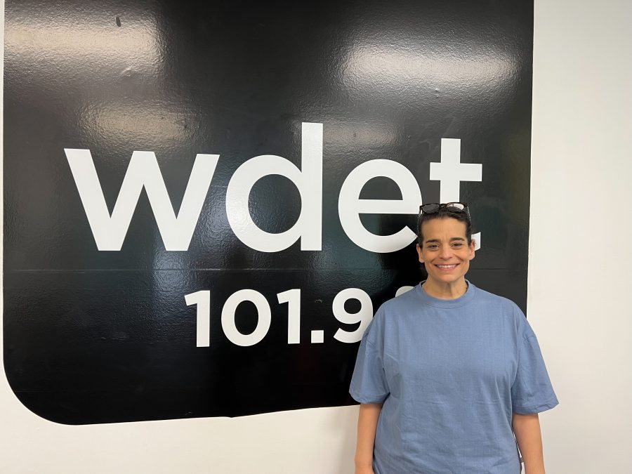 Jessica Kirson stands in front of the WDET 101.9 FM sign at the station