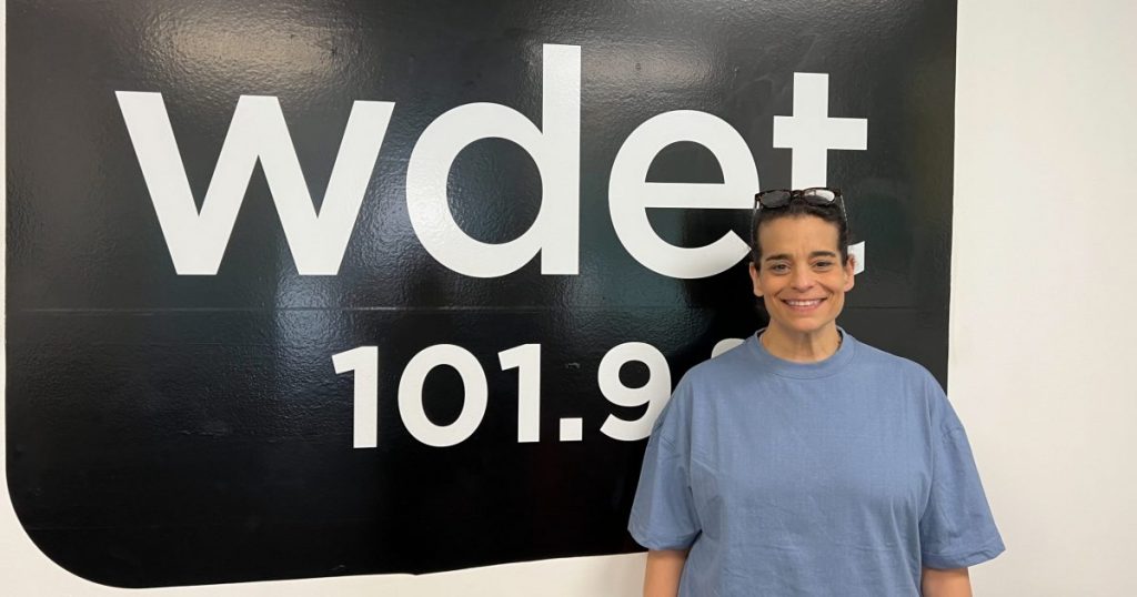 Jessica Kirson stands in front of the WDET 101.9 FM sign at the station