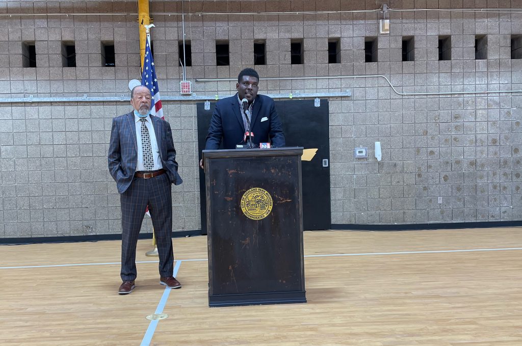 Wayne County Land Bank Executive Director Anthony Cartwright standing behind a podium next to Highland Park Mayor Hubert Yopp at the press conference on Monday