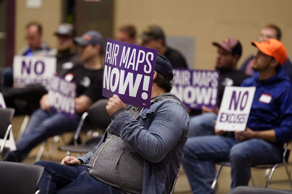 Protesters attend a meeting of Michigan's new Independent Citizens Redistricting Commission on Oct. 21, 2021, in Lansing, Mich.