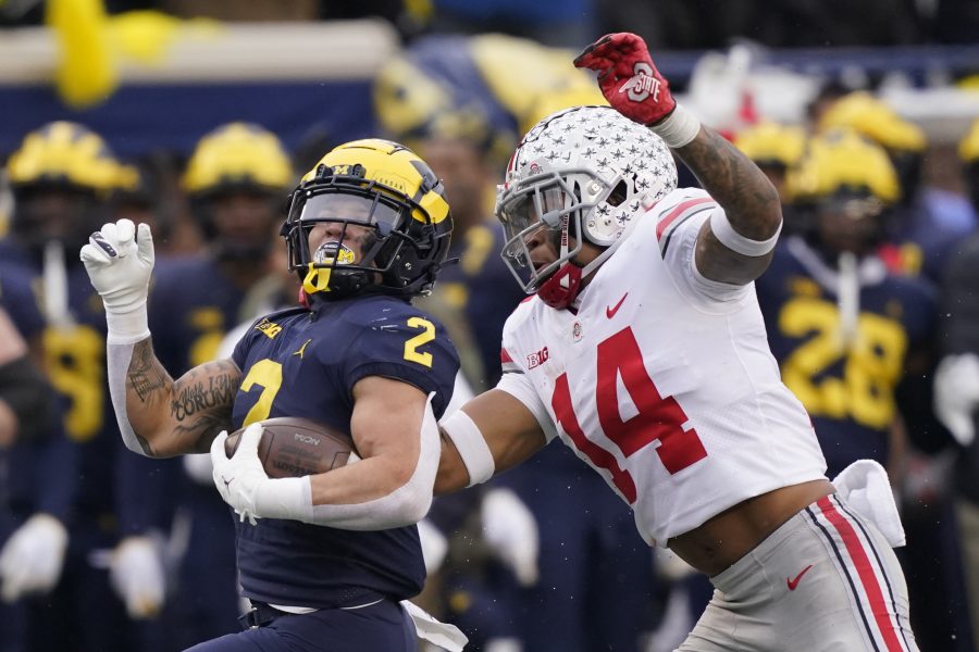 Michigan running back Blake Corum (2) is chased by Ohio State safety Ronnie Hickman during the second half of an NCAA college football game Nov. 27, 2021, in Ann Arbor, Mich.