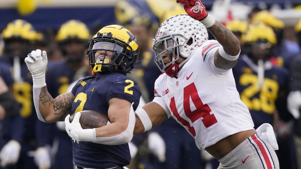 Michigan running back Blake Corum (2) is chased by Ohio State safety Ronnie Hickman during the second half of an NCAA college football game Nov. 27, 2021, in Ann Arbor, Mich.
