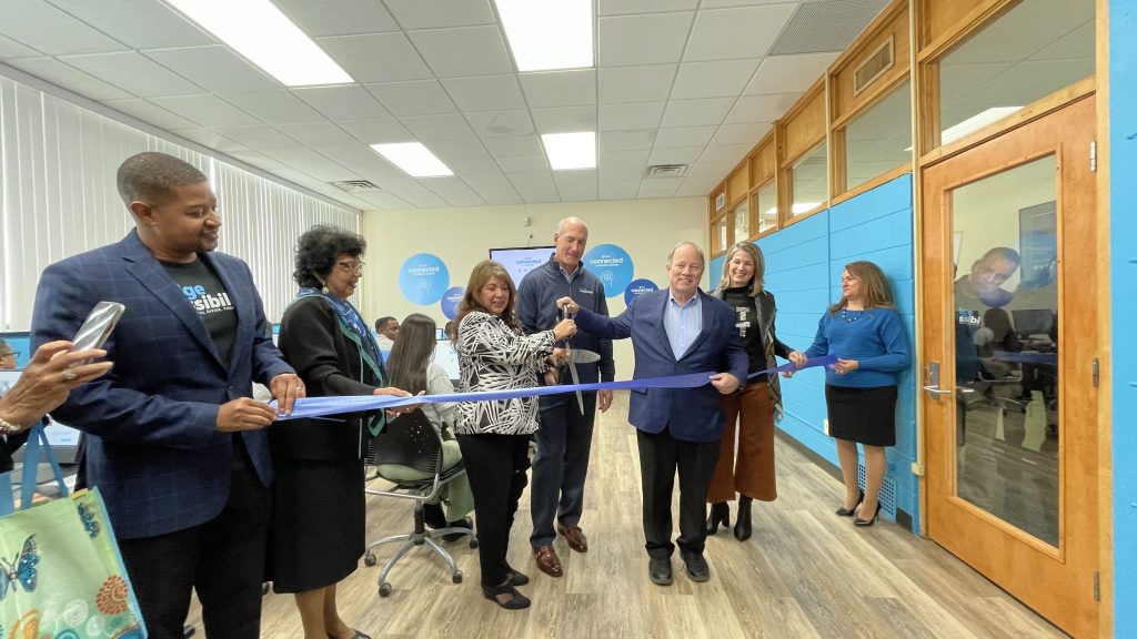 Eva Garza Dewaelsche, John Stankey and Mayor Mike Duggan cut a blue ribbon with a large pair of scissors at the new Connected Learning Center
