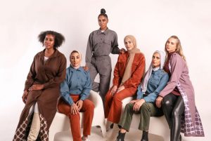 six multi-cultural women pose in stylish muted tone outfits