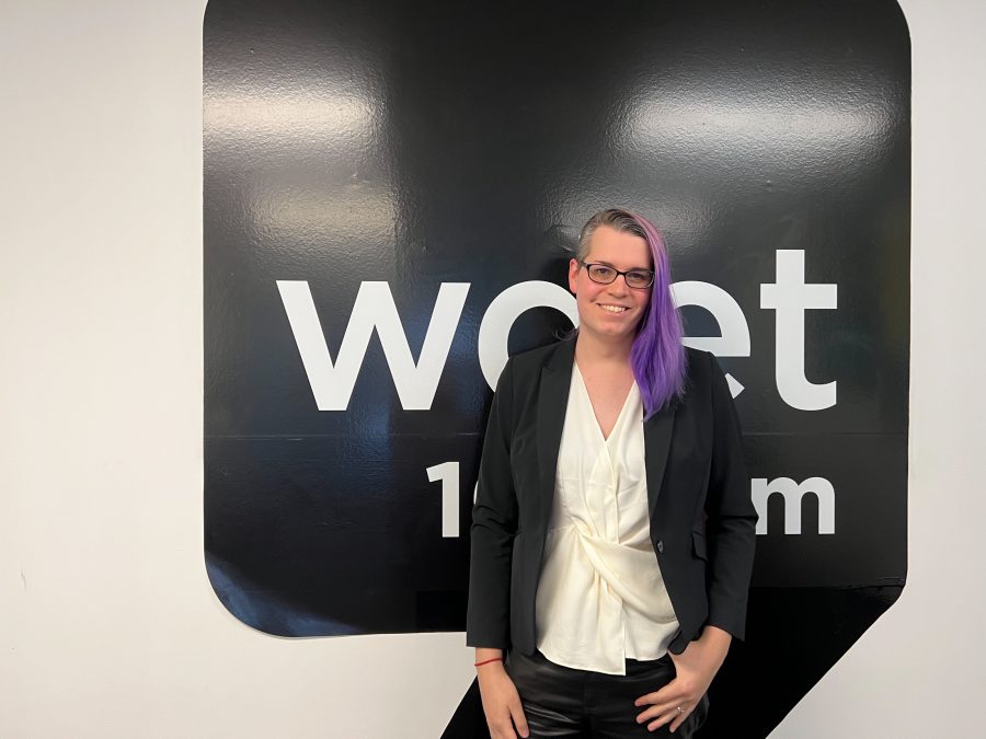 kali scales smiles in front of the WDET logo at our station