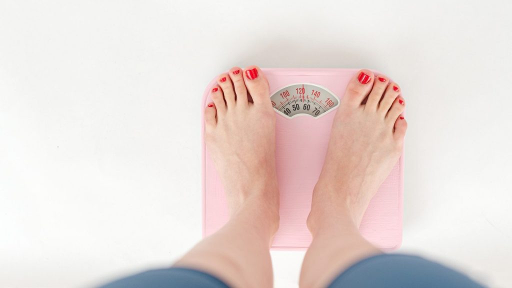 Person weighs themself on the weight scale