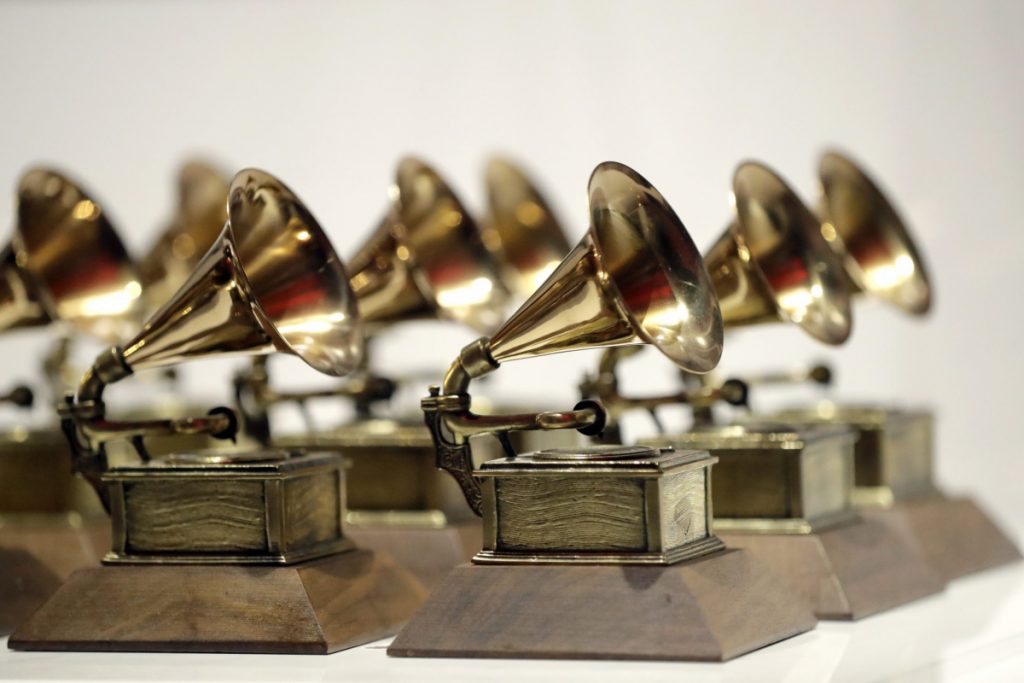 several golden Grammy award trophies gathered against a white background