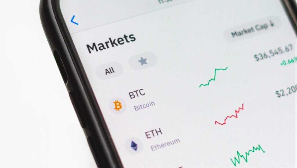 a smartphone shows the markets of different cryptocurrencies