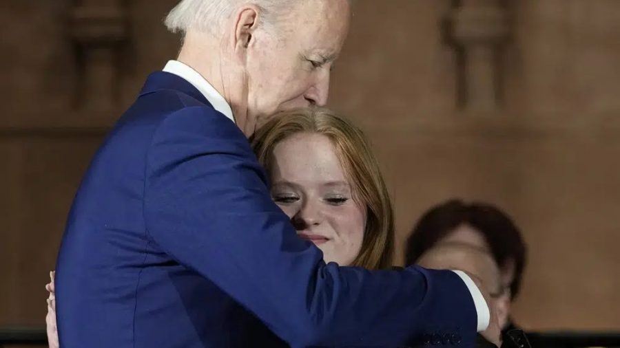 President Joe Biden hugs Sandy Hook survivor Jackie Hegarty, who introduced him, during an event in Washington, Wednesday, Dec. 7, 2022, with survivors and families impacted by gun violence for the 10th Annual National Vigil for All Victims of Gun Violence.