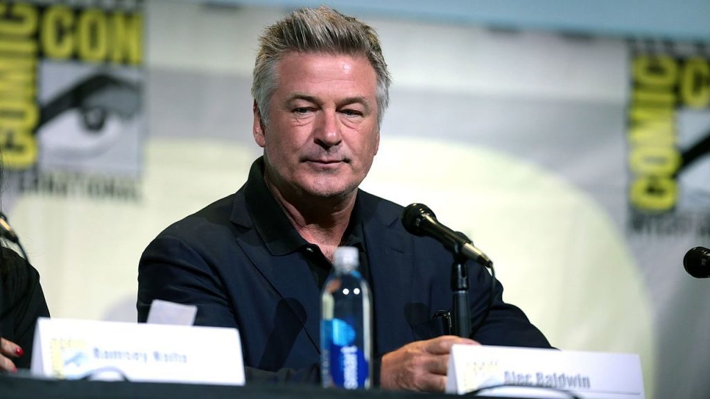 actor Alec Baldwin sits on a panel at Comic Con