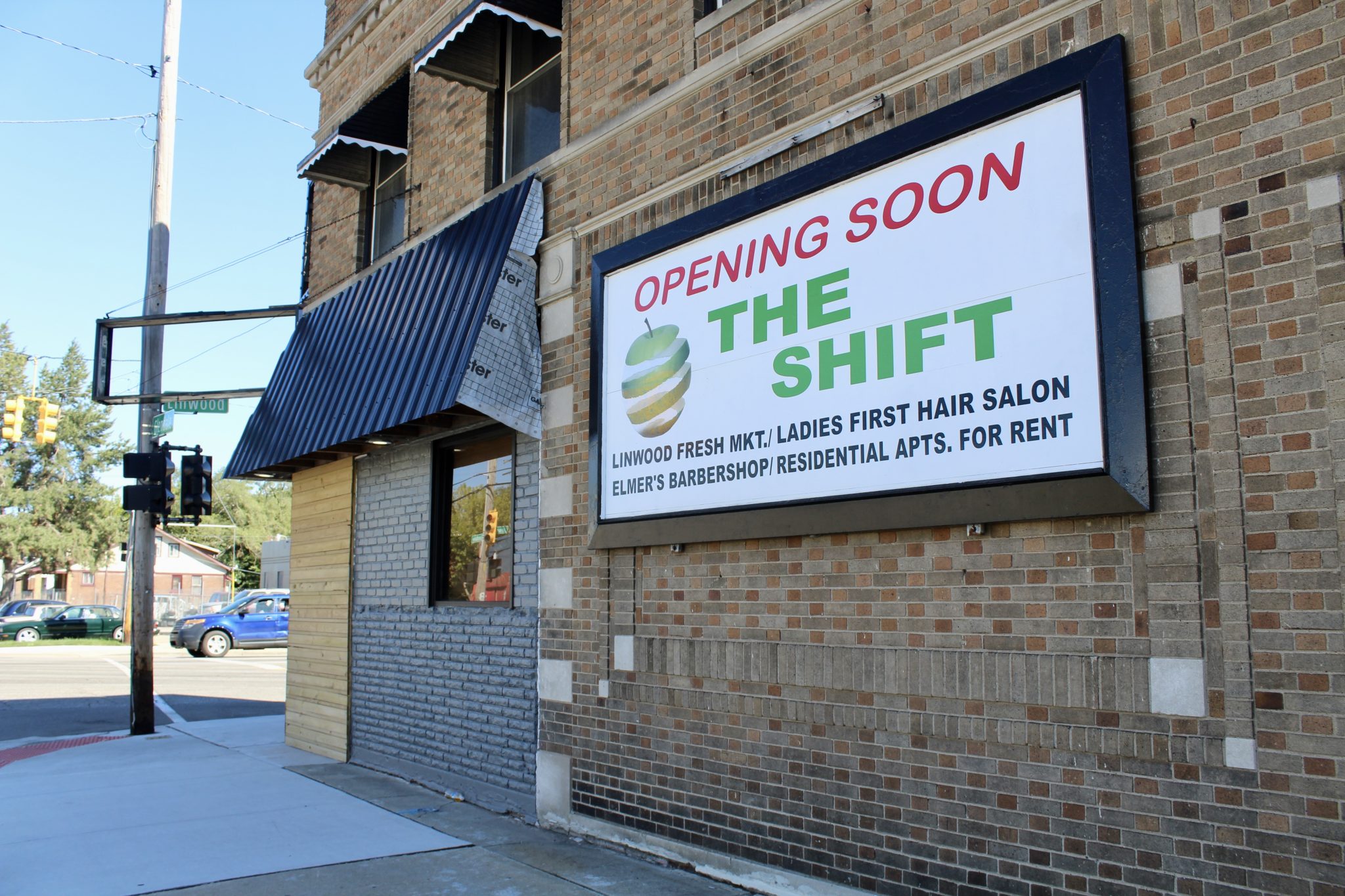 exterior of a brick building with a sign that reads, "Opening soon: The Shift, including Linwood Fresh Market"