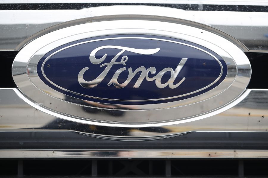 In this Sunday, Oct. 20, 2019, photograph, the company logo shines off the grille of an unsold 2019 F-250 pickup truck at a Ford dealership in Littleton, Colo.