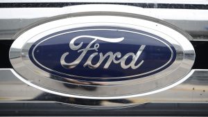 In this Sunday, Oct. 20, 2019, photograph, the company logo shines off the grille of an unsold 2019 F-250 pickup truck at a Ford dealership in Littleton, Colo.