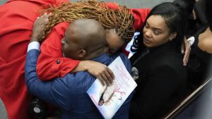A mourner hugs Jerome Lloyd-Anderson and Dawana Davis, father and mother of Michigan State University shooting victim Arielle Anderson at a funeral in Detroit, Tuesday, Feb. 21, 2023.