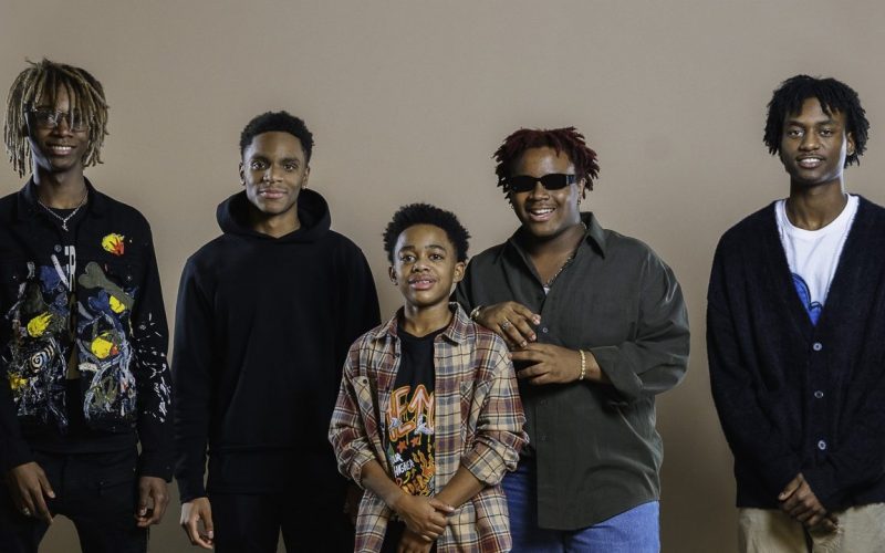 five young Black men pose in a line