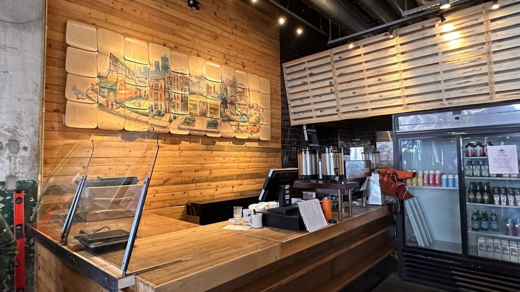 a wooden counter with a painted wooden mural depicting the Cass Corridor