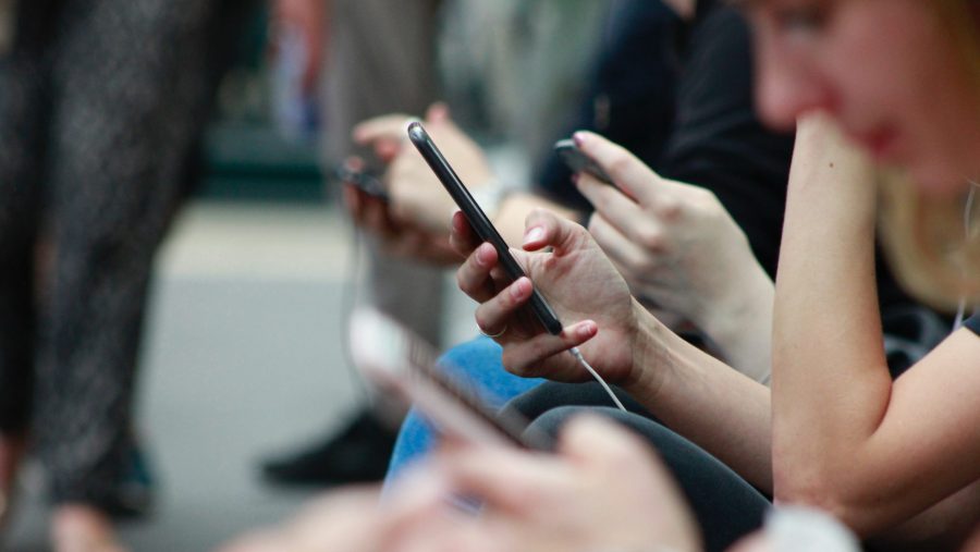 Stock photo of people looking at their smartphones.