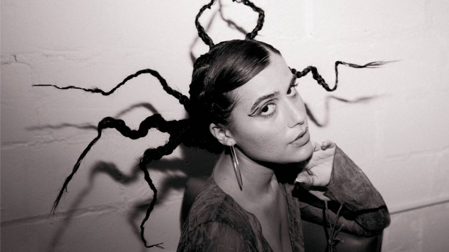 Black and white image of a woman with geometric braided hair and graphic eyeliner.