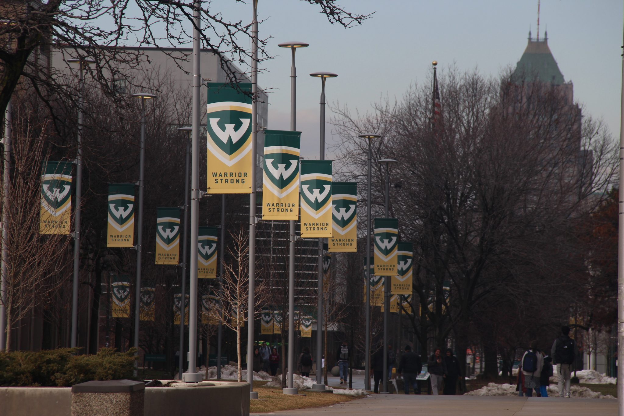green and gold banners on light posts that read "warrior strong" with the Wayne State "w"