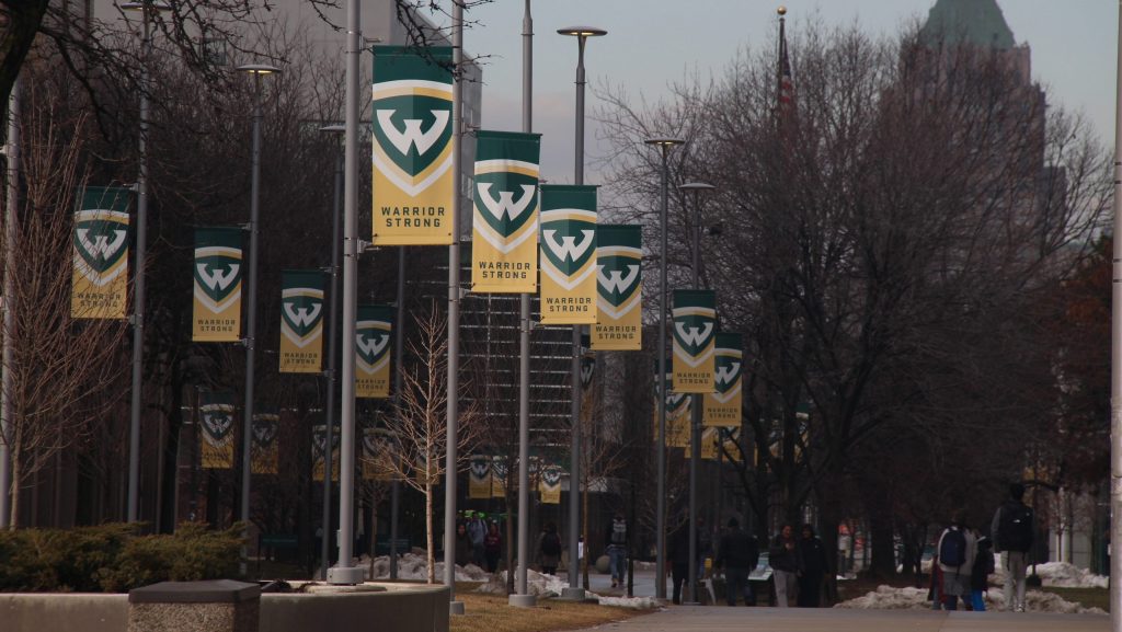 green and gold banners on light posts that read "warrior strong" with the Wayne State "w"