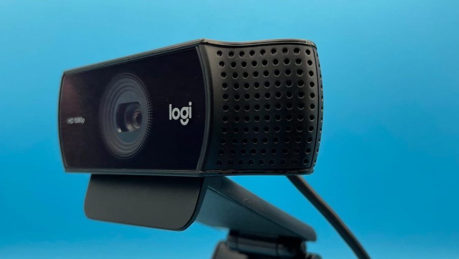 A black Logitech camera against a bright blue background