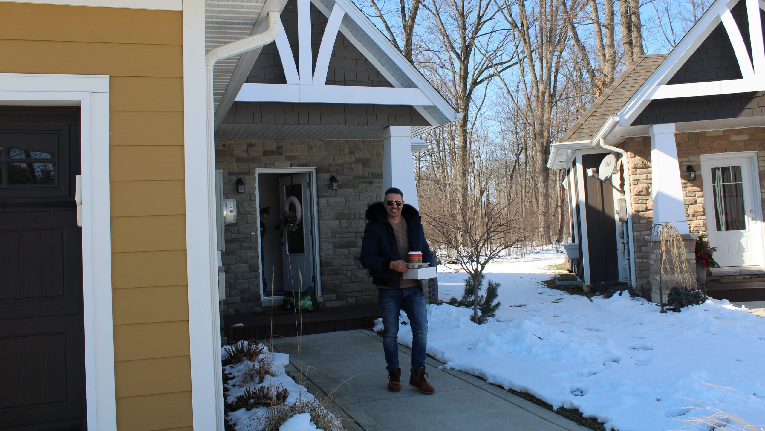 Dave Buzzeo steps out of his AirBnB property while his wife, Melissa Buzzeo, peaks out the front door.