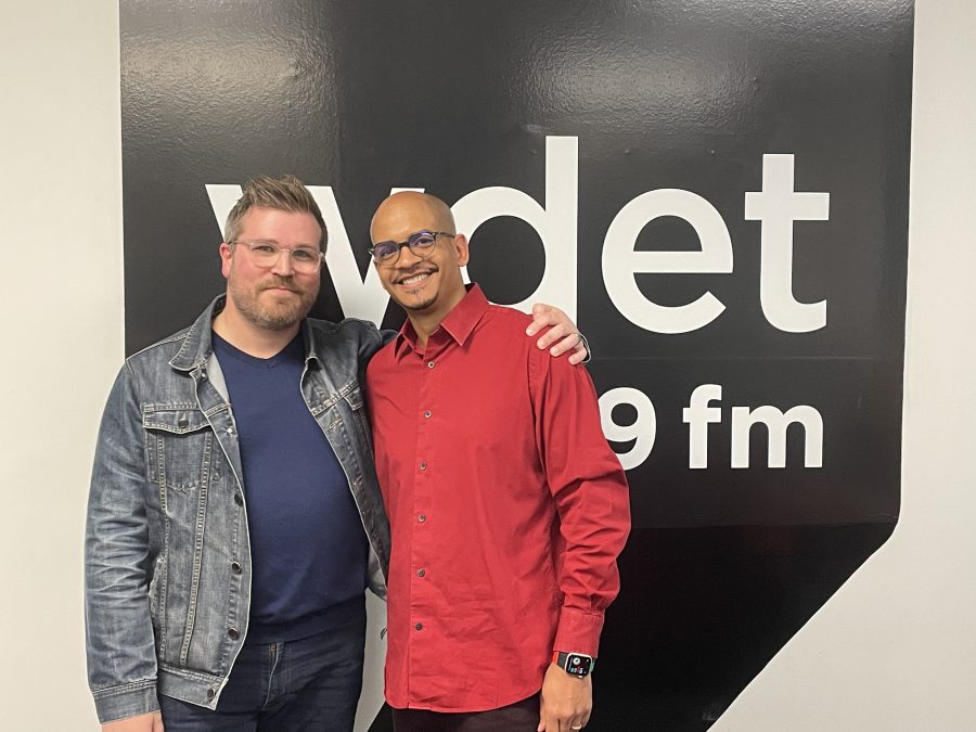 Brad Torreano and Timashion Jones pose in front of the WDET logo
