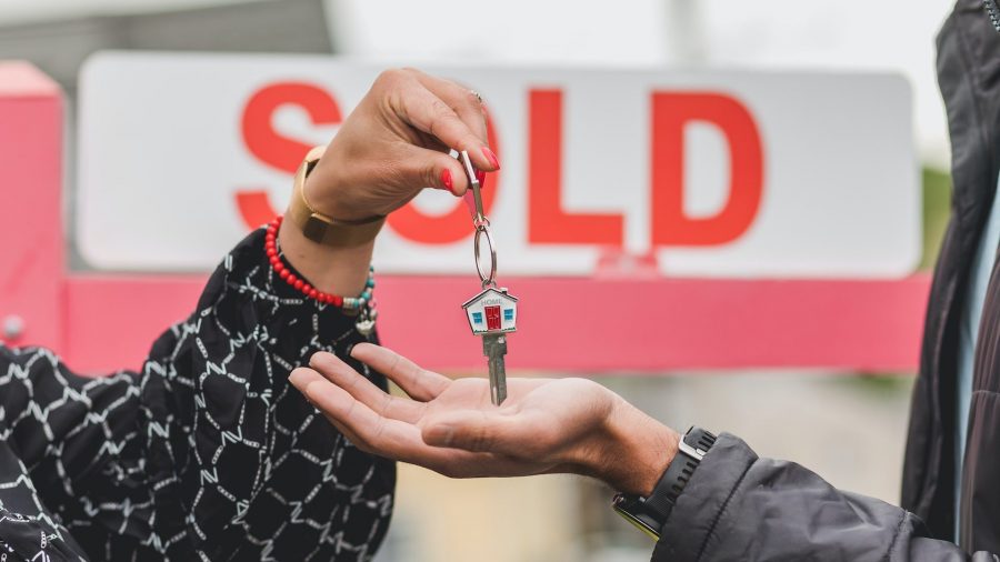 Photo of person receiving keys to the house they just purchased.