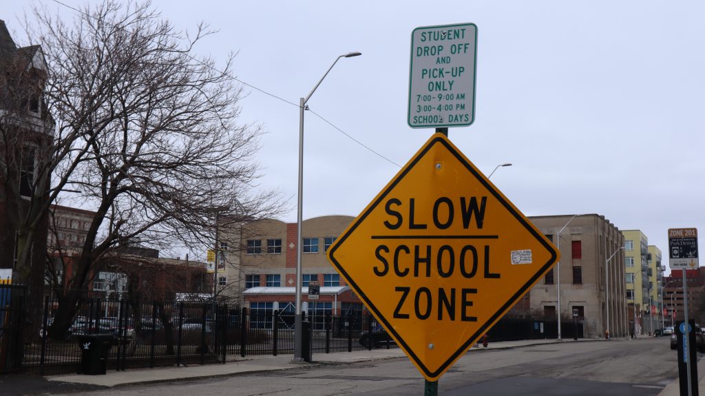 A photo of a "slow school zone" traffic sign.
