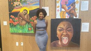 DaJaniere Rice poses with her paintings