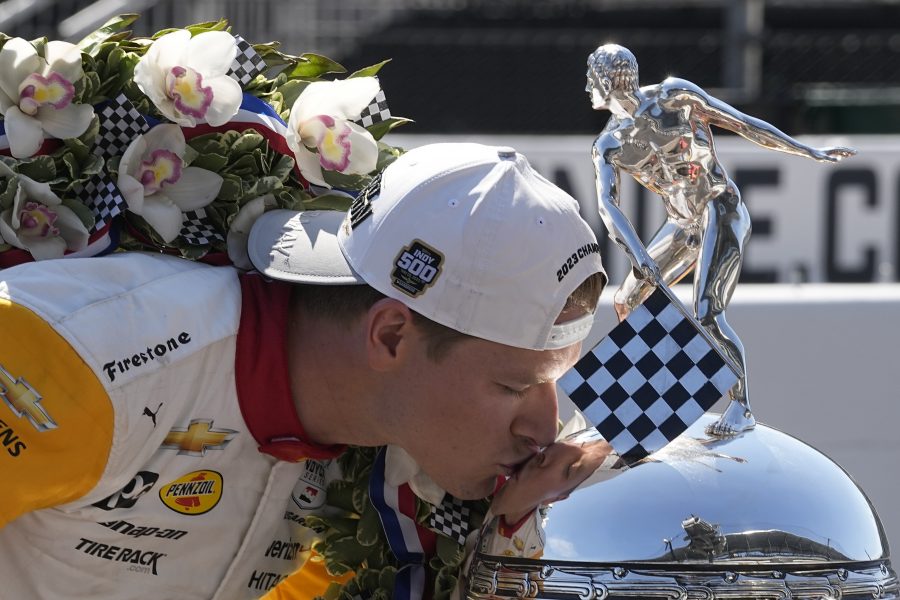 Josef Newgarden kisses the Borg-Warner Trophy during the traditional winners photo session at Indianapolis Motor Speedway, Monday, May 29, 2023, in Indianapolis. Newgarden won the 107th running of the Indianapolis 500 auto race Sunday.