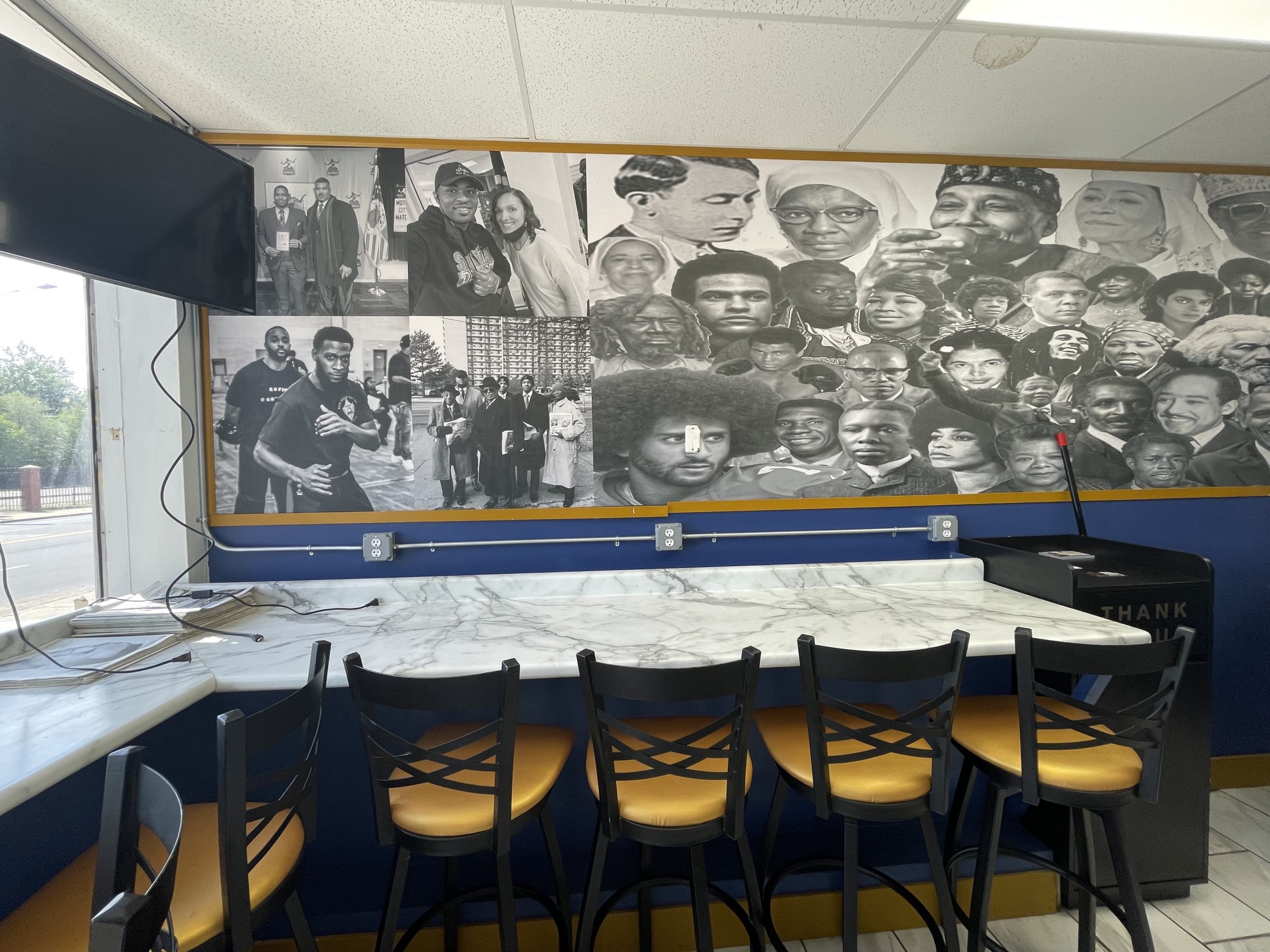 Interior of Supreme Cafe, featuring a mural of historic and modern day Black leaders