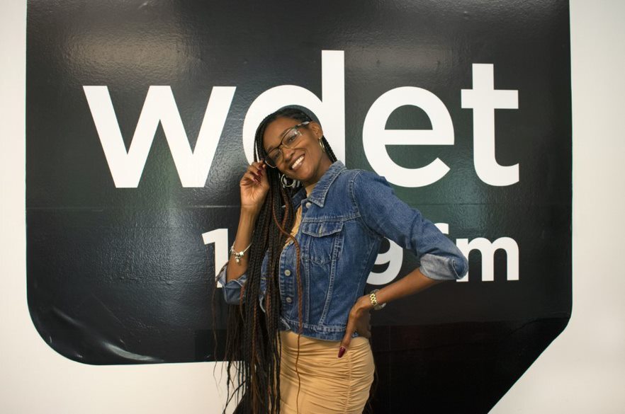 Sharon Freed-Moreland smiles in front of the WDET logo